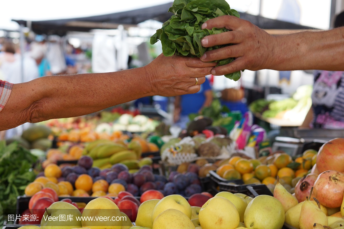 商品在市场上流转,买卖双方的手中拿着一份沙拉,柜台上摆满了水果和蔬菜
